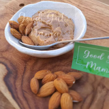 Almond Butter from Good Gut Mama, available at Elmeraki, displayed in a jar with a spoon and almonds.