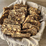 Nourish Me Crackers from Good Gut Mama, available at Elmeraki, displayed in a bowl with nuts and seeds.