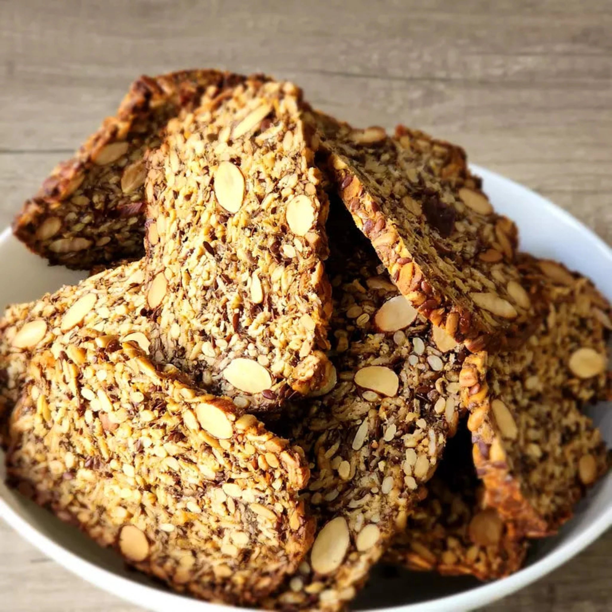 Roll With It Crackers from Good Gut Mama, available at Elmeraki, displayed in a bowl with nuts and seeds.