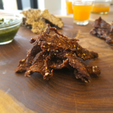 Beef Jerky from Good Gut Mama, available at Elmeraki, displayed in a pack with fresh herbs and spices.