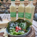 Fermented Caesar Dressing from Good Gut Mama, available at Elmeraki, displayed in a bottle with fresh salad greens.