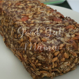 Roll With It, Vegan Loaf from Good Gut Mama, available at Elmeraki, displayed on a wooden board with slices and seeds.