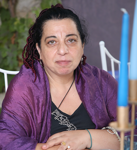 Dr. Souha Nassreddine, holistic gynecologist and integrative medicine practitioner, smiling warmly in her clinic.