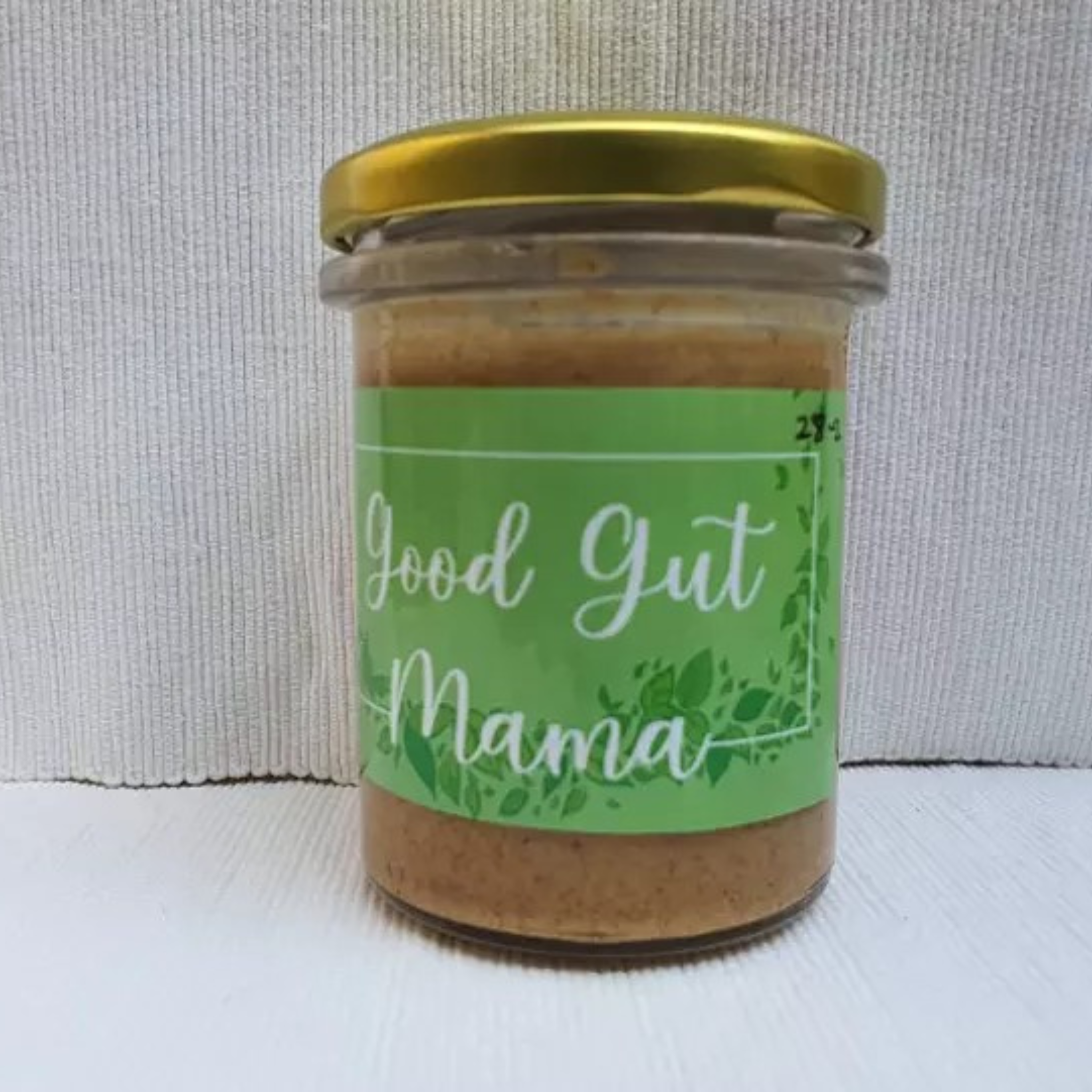 Almond Butter from Good Gut Mama, available at Elmeraki, displayed in a jar with a spoon and almonds.