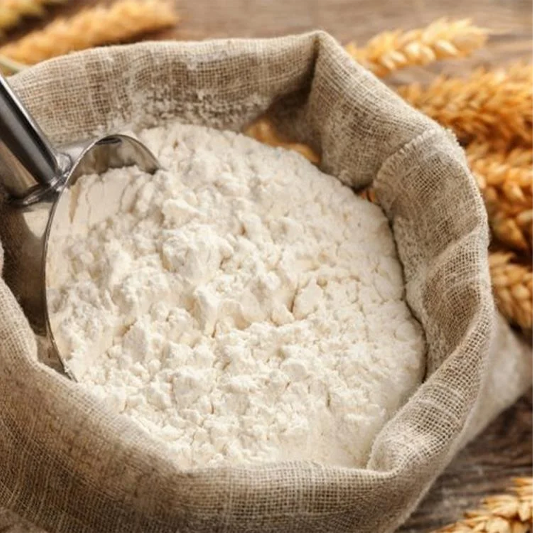 Brown Flour by Tabi3y, available at Elmeraki, displayed in a bag with fresh baked bread and muffins.