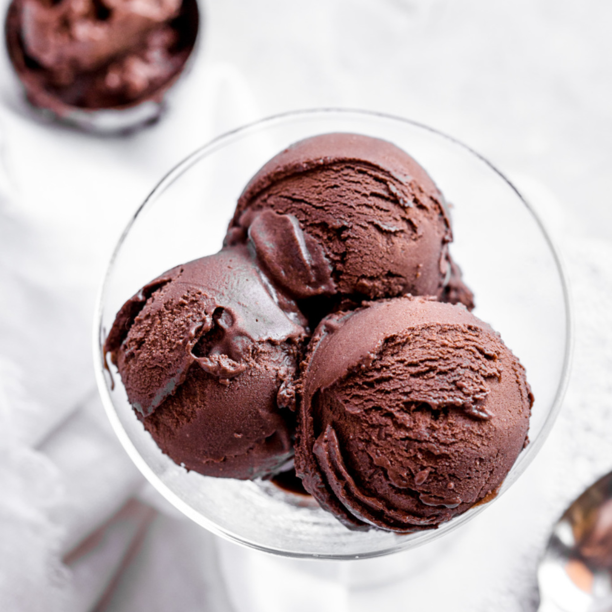 assortment of 10 ice cream flavors in tubs – chocolate, mango, pistachio, matcha, and more.