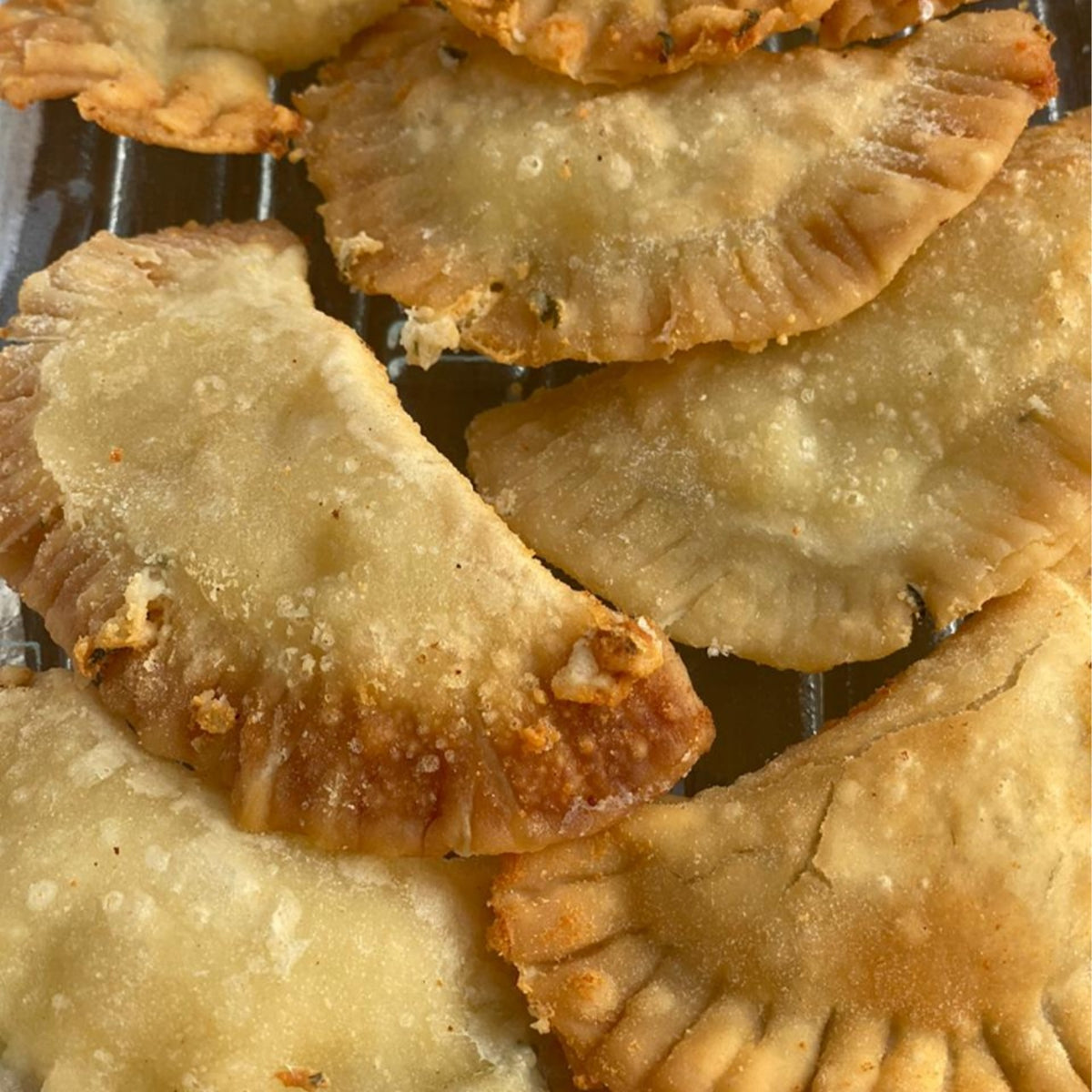 A plate of golden, fried Komm El Dikka Cheese Stuffed Sambosak, a frozen Egyptian pastry appetizer from El Meraki.