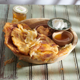 A fresh, flaky Balady Feteer, a traditional Egyptian layered bread from Komm El Dikka, delivered by El Meraki.