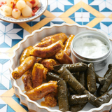 A plate of Komm El Dikka's Stuffed Vine Leaves (Warak Enab), a traditional 12-piece frozen Egyptian appetizer from El Meraki.