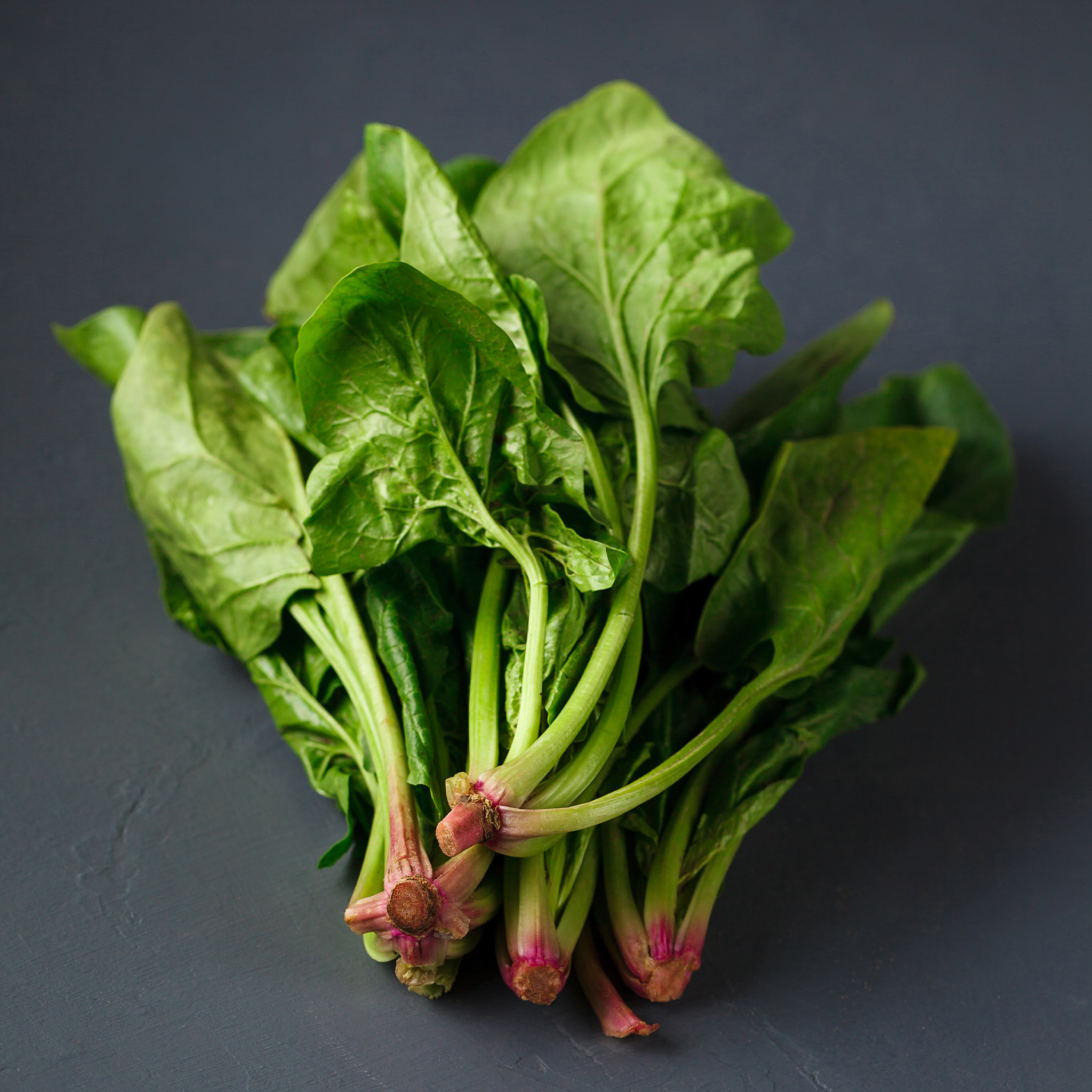 Fresh Spinach by Tabi3y, available at Elmeraki, displayed in a basket with vibrant green leaves.