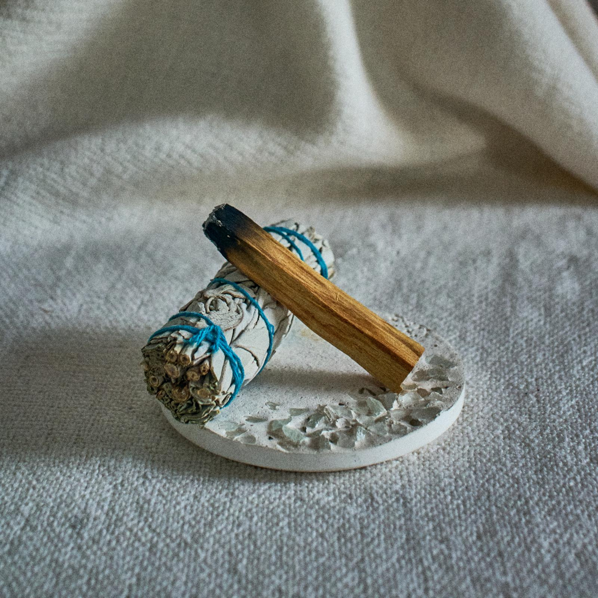 White sage and palo santo bundle with ceramic holder for home cleansing and meditation