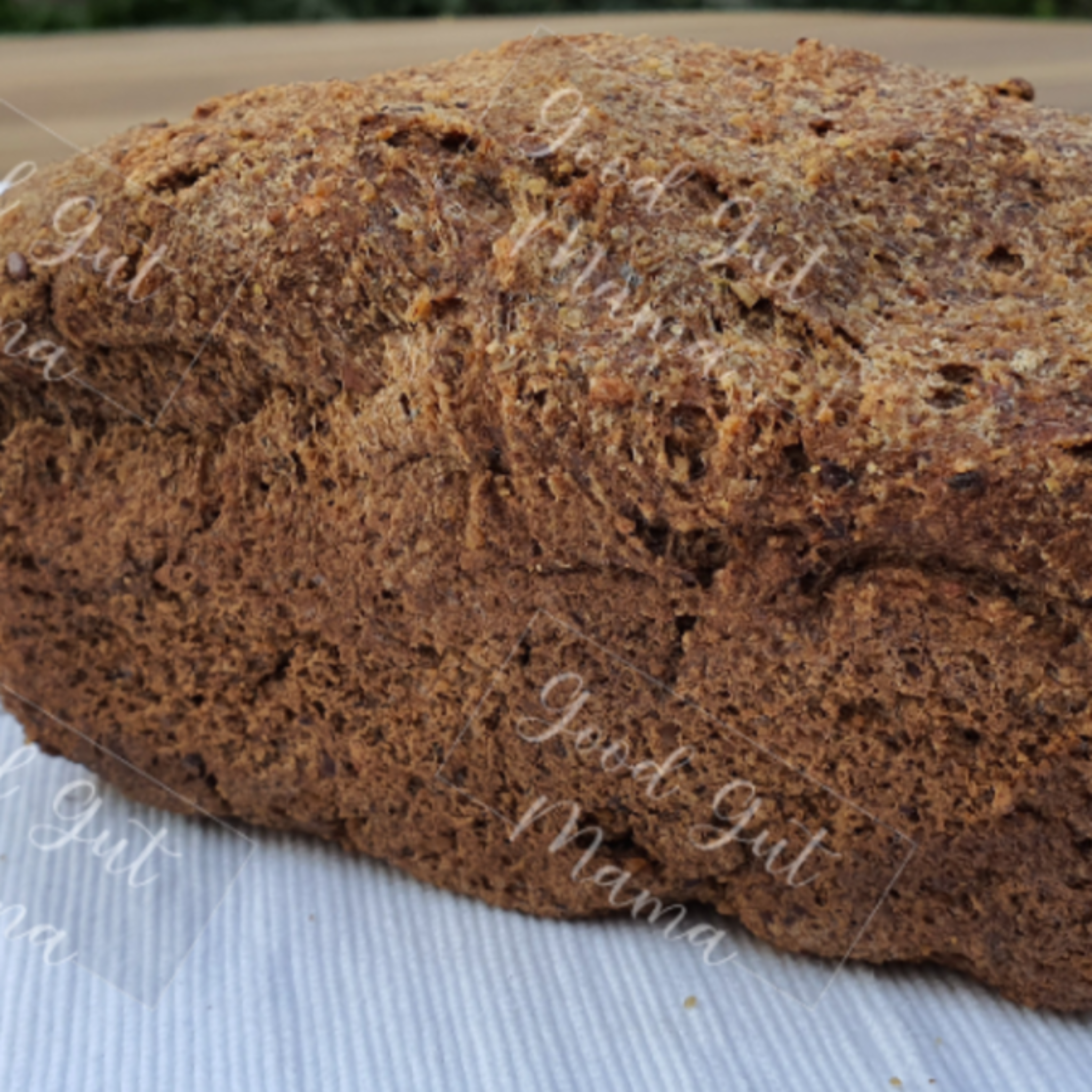 Almond Keto Dinner Loaf from Good Gut Mama, available at Elmeraki, displayed on a wooden board with slices and seeds