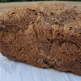 Almond Keto Dinner Loaf from Good Gut Mama, available at Elmeraki, displayed on a wooden board with slices and seeds