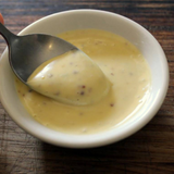 Jar of creamy Good Gut Mama Mayonnaise made in Egypt, with a spoonful showing its rich texture.