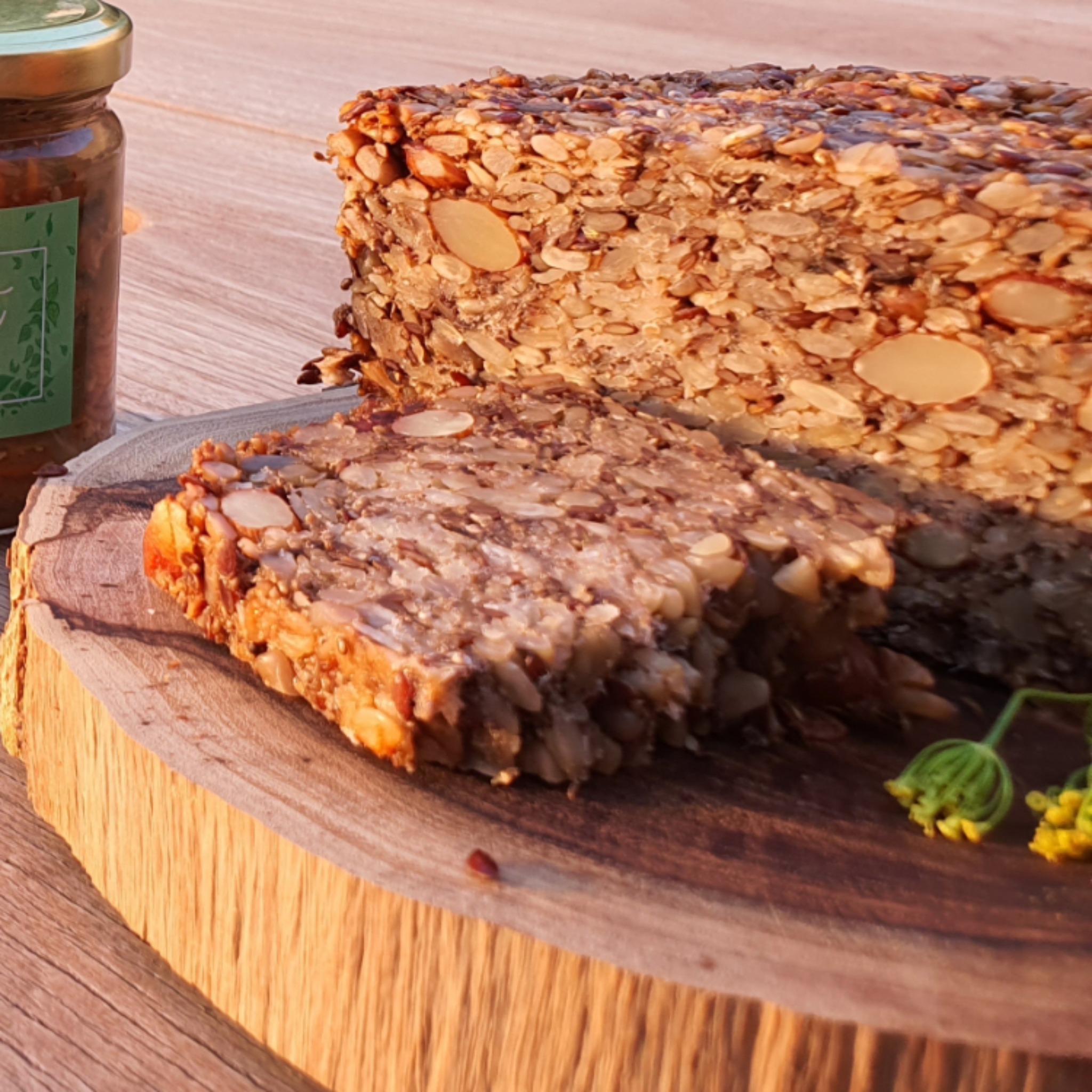 Roll With It, Vegan Loaf from Good Gut Mama, available at Elmeraki, displayed on a wooden board with slices and seeds.